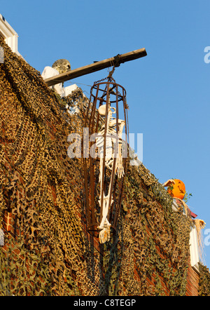 Skelett mit Zombie auf in Käfig an einer Wand hängen. Stockfoto