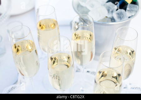 Nahaufnahme der Gläser gefüllt mit Weißwein und Flasche im Eiskübel Stockfoto