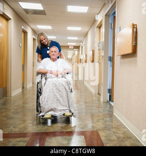 USA, Utah, Ogden, junge Krankenschwester ist senior Mann im Rollstuhl schieben. Stockfoto