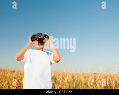 USA, Oregon, Wasco, junge stehend im Weizenfeld, Blick durch ein Fernglas Stockfoto