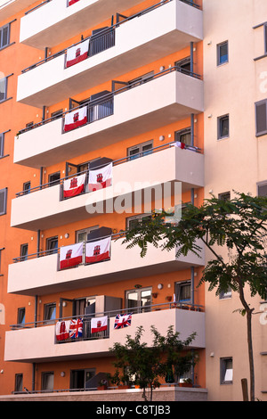 Wohnblock mit Fahnen auf dem Balkon. Detail des Blocks in Gibraltar. Stockfoto