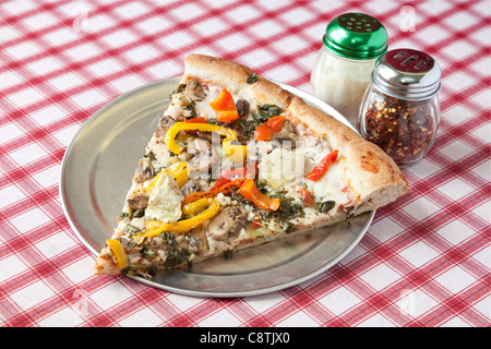 Italienische vegetarische Pizza auf einer italienischen Stil rote und weiße Tischdecke Stockfoto