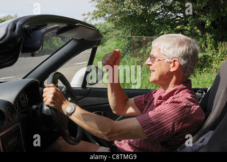 Männliche Fahrer in Sportwagen zeigt Wut und winken Faust Stockfoto