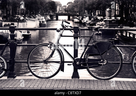 Typisch männliche niederländischen Fahrrad gesperrt auf einem Kanal Geländer in Amsterdam. Stockfoto