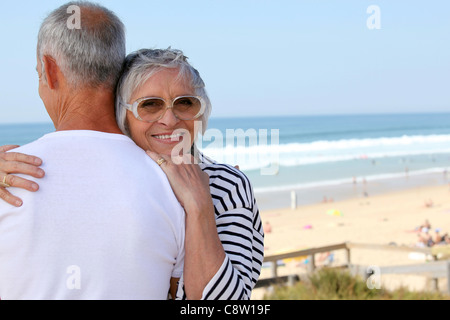 eine ältere Frau umarmt ihr Mann in der Nähe des Meeres Stockfoto