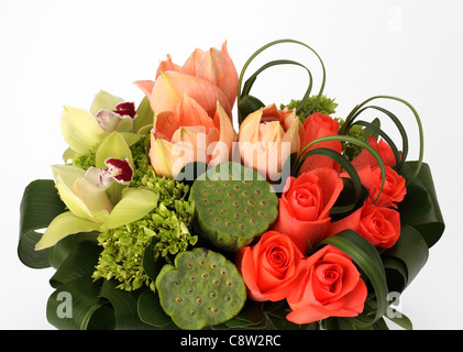 Eine Nahaufnahme von einem bunten Blumenstrauß. Orange Rosen, grüne Lilie Samen Pads, rosa Tulpen, Cymbidium Orchideen Stockfoto