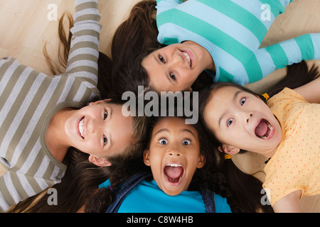 Studio-Porträt von vier Mädchen, die am Boden liegend Stockfoto