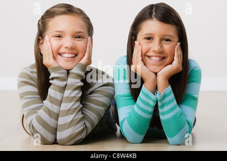 Studio-Porträt von zwei Mädchen am Boden liegend Stockfoto