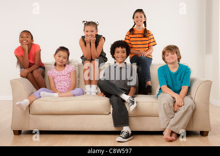 Studioportrait von sechs Kindern auf sofa Stockfoto