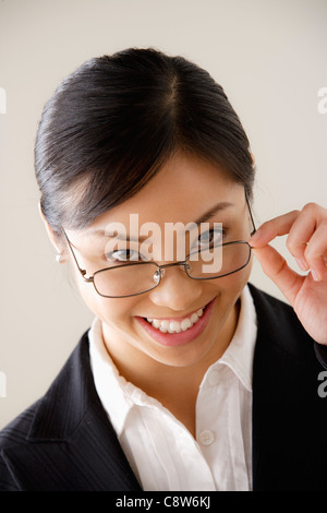 Portrait von junge Geschäftsfrau mit Blick auf Gläser Stockfoto