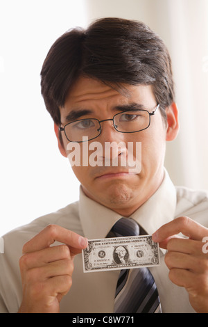 Traurig Geschäftsmann hält eine Dollar-note Stockfoto