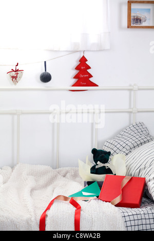 Weihnachtsschmuck hängen, String und Geschenke Box auf Couch Stockfoto