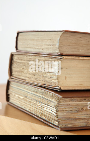 vertikalen Stapel von drei alten Hardcover Bücher über eine hölzerne Oberfläche, Studio-Fotografie Stockfoto