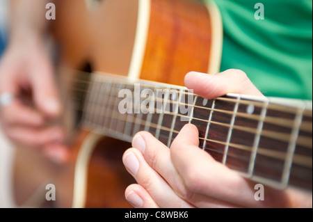 Gespielt wird auf der akustischen Gitarre Gitarrensaiten Stockfoto