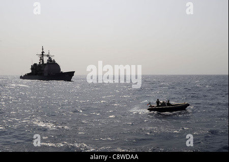 Festrumpf-Schlauchboot Manöver während einer Internat in der Nähe der geführte Flugkörper Kreuzer USS Anzio Stockfoto