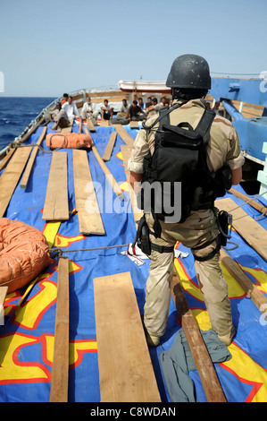 Der Besuch, Board, Suche und Beschlagnahme Teammitglied bewachen die Crew an Bord einer Dhau während einer boarding-operation Stockfoto