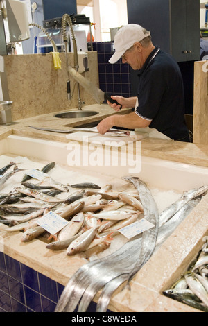 Portugal Algarve Lagos Mercado Municipal Fischmarkt 1924 alte ältere Anbieter männlich Mann Baseballmütze Reinigung fische Makrele Stockfoto