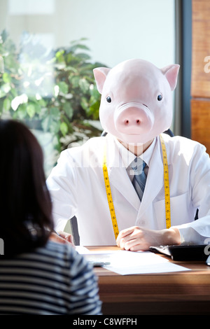 Pig Head Ernährungsberaterin mit Patienten am Schreibtisch Stockfoto