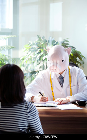 Pig Head Ernährungsberaterin mit Patienten am Schreibtisch Stockfoto