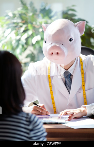 Pig Head Ernährungsberaterin mit Patienten am Schreibtisch Stockfoto