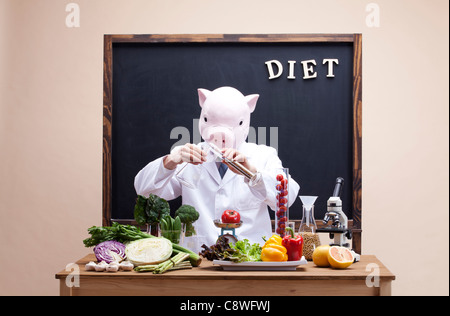 Pig Head Ernährungsberaterin Punkt Experiment mit Gemüse Stockfoto