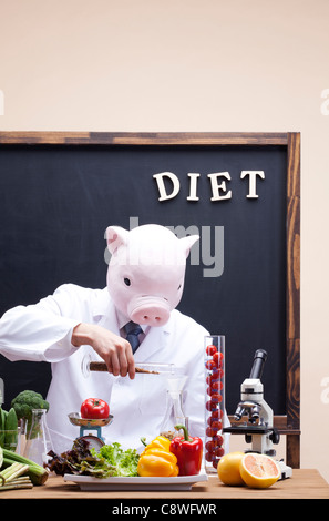 Pig Head Ernährungsberaterin Punkt Experiment mit Gemüse Stockfoto