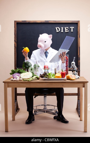 Pig Head Ernährungsberaterin Punkt Experiment mit Gemüse Stockfoto