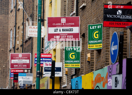 Cluster "Zu lassen", "Lassen Sie sich durch" und "For Sale" Schildern an Gebäuden in Brick Lane London England UK Stockfoto