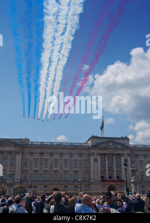 Trooping die Farbe Red Arrows fliegen vorbei an Buckingham Palace mit roten, weißen und blauen Kondensstreifen Himmel London England UK Stockfoto