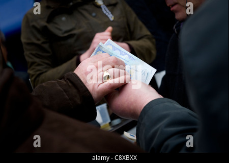 Geldwechsel, die Hände beim Cheltenham-Pferderennen. Stockfoto