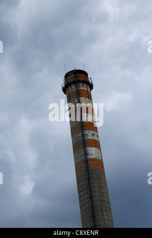 Industrielle Schornstein gemalt, rot und weiß mit einem dramatischen Himmel im Hintergrund Stockfoto