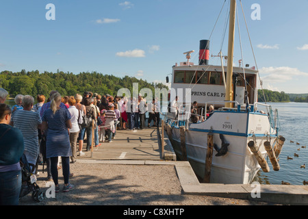 Menschen Schlange, um auf die s/s "Prins Carl Philip" am Steg Drottningholm, Schweden Stockfoto