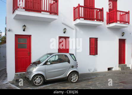 Mini Auto parkte vor einer roten & weiße Residenz auf der griechischen Insel Mykonos. Stockfoto