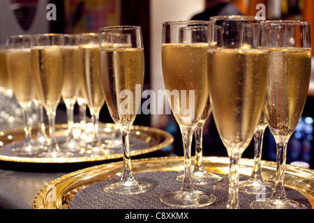Gläser Champagner auf einem goldenen Tablett. Stockfoto