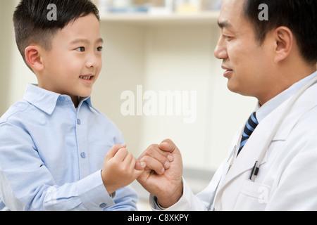 Junge und Arzt Pinky Promise Stockfoto