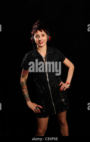 junge Frau mit Tattoos auf dem Arm trägt ein paar headhones Stockfoto