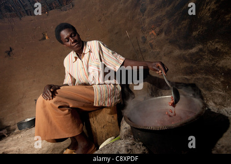 Eine Frau kocht einen Topf Bohnen über dem offenen Feuer in Katirio Dorf, Kibuku District, Uganda. Stockfoto