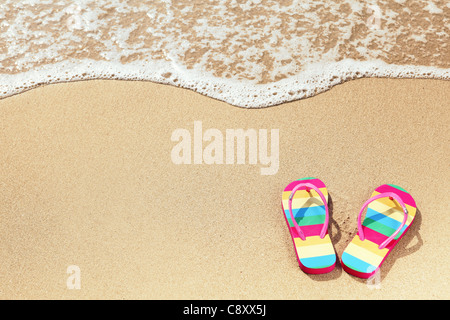 Tropischer Urlaub Konzept--Flipflops auf einem sandigen Strand Stockfoto