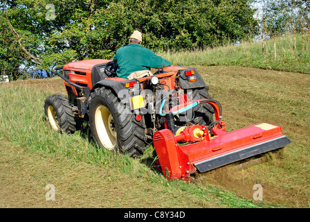 Kleiner Bauernhof Traktor Busch Beschlag auf einer Wiese in Trentino Alto Adige. Italien Stockfoto