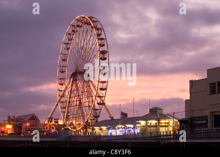 Ein Riesenrad auf dem South Pier in Blackpool bei Sonnenuntergang. Stockfoto