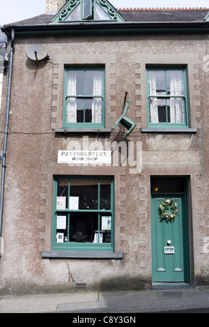 Stuhl an der Wand außerhalb Sattlerei in Narberth, Pembrokeshire, Wales Stockfoto