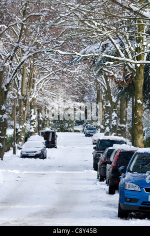 Autos parken entlang Baum gesäumt verschneiten Straße in größere Manchester 2010 Stockfoto