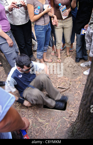 Asien, Vietnam, Cu Chi nr. Ho-Chi-Minh-Stadt (Saigon). Cu Chi Tunnel. Tourist in eine typische kleine und getarnten Tunnel... Stockfoto