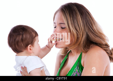 Baby Sohn teilen einen Cookie mit seiner Mutter (isoliert auf weiss) Stockfoto