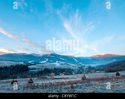 erste Herbst Frost auf der Weide mit Heu und Sonnenaufgang in den Bergen-Dorf Stockfoto