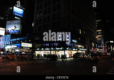 Neon Night-Time-Ansicht Autos, Menschen zu Fuß durch Straßenecke Windows Computer Videothek, 7th Avenue West 50th Street, New York Stockfoto