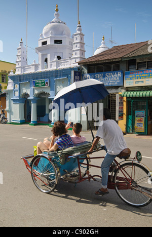 Touristen auf eine Rikscha vor der muslimischen indischen Nagore Durgha Sherif in Georgetown, Penang Island, Malaysia Stockfoto