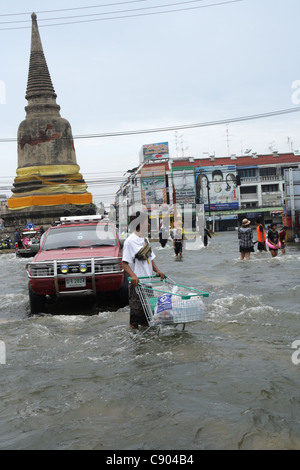 Ein Mann mit seinen Warenkorb Warenkorb ansehen in Hochwasser auf Straße in der Provinz Ayutthaya, Thailand Stockfoto