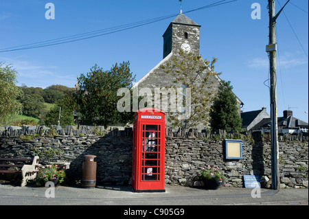 Eine rote Telefonzelle steht vor der Kirche St. Peter Ad Vincula in Pennal, Powys, North Wales, UK Stockfoto