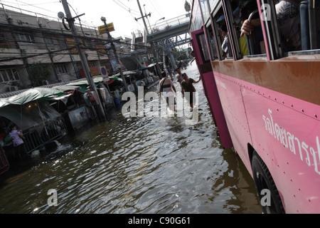 Menschen waten im Hochwasser an der Phetkasem Road in Bangkok Stockfoto